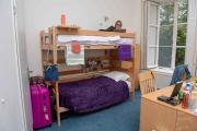 A student sitting in a Kasteel Well bunk bed