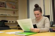 Person sitting at a table reading a paper