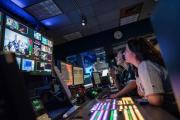 Students working in the Journalism Production Center, at a switchboard with multiple monitors