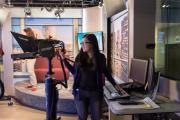 A student operating a professional camera in a Television Studio