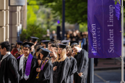 A group of students going down the Boylston Alley in regalia