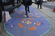 An abstract mural on the sidewalk composed of blues and reds 
