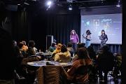 Students performing for a small crowd inside an intimate theater space