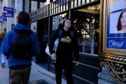 A student walking down the street in front of Emerson College