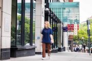 a student walking on the sidewalk in front of the Piano Row building