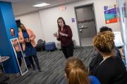 An Emerson staff member stands talking to a few community members who form a circle around her.