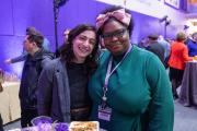 Two attendees of the Community Celebration Lunch Reception stand together smiling at the camera.