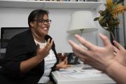 An advisor talking with a student in an office, smiling