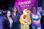 A group posing for a photo at an Emerson event, with one individual dressed in a bright yellow chicken costume