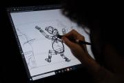 A person digitally drawing a wire frame for a figure onto a computer.