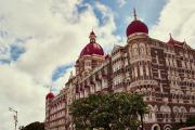 A large red brick hotel with rounded dome roofs on cloudy blue sky