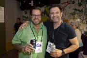 Two alumni smiling for a photo while holding beverages at an Alumni Weekend event