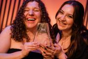 Two students holding a shared ERA award trophy