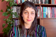 Maria Corrigan wearing a striped shirt in front of a large bookcase