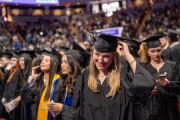 A crowd of students at their Commencement ceremony, wearing caps and gowns, stoles, and other assorted regalia.