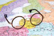 Round eyeglasses over a colorful map of Eastern Europe