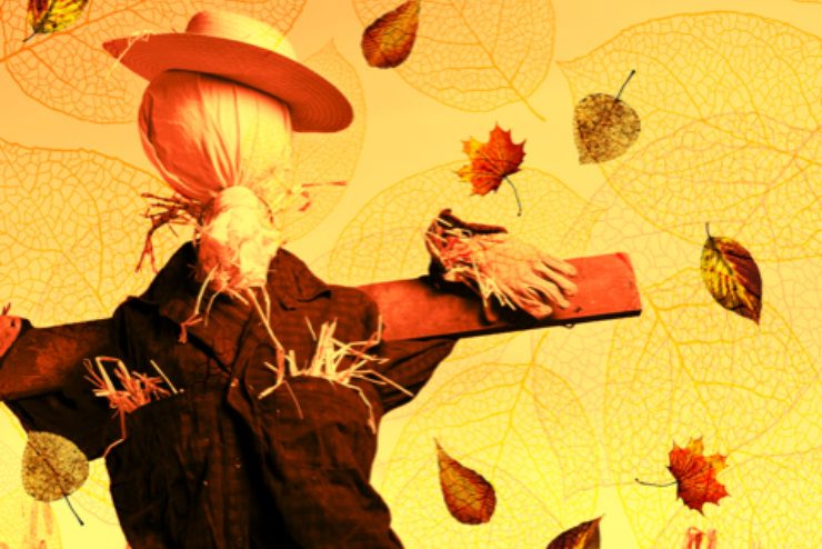 A scarecrow amongst fallen leaves and a yellow background
