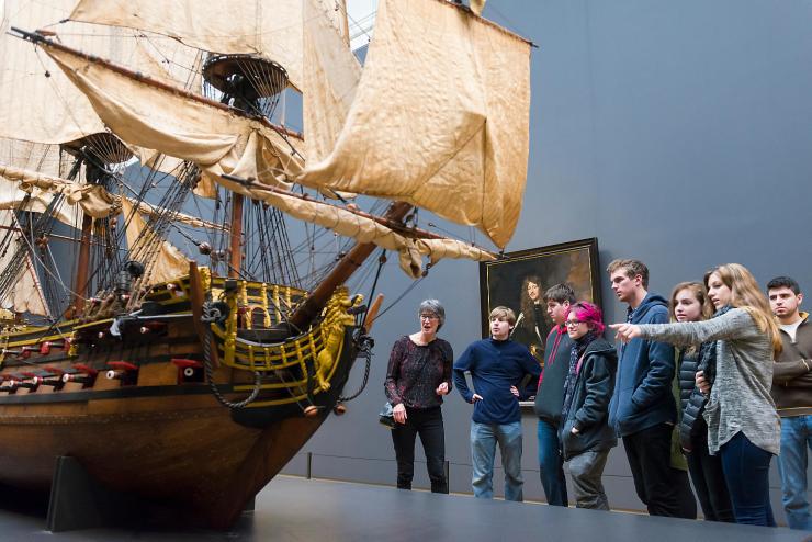 Students admiring a ship in a museum