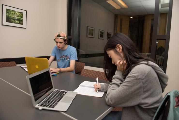 Two students studying together with laptops at a room in the Campus Center