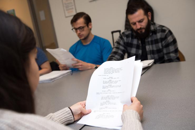 Students at table reviewing film script together