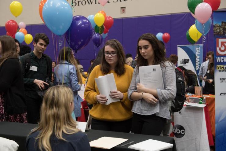 Two students interacting with potential employer at Career Fair