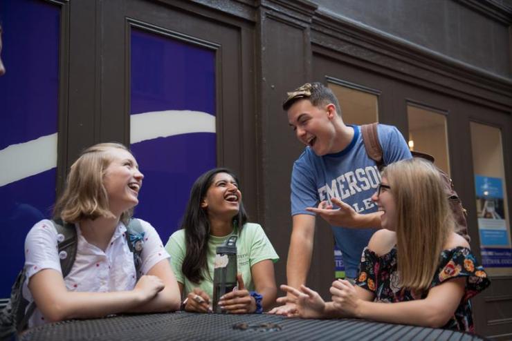 Students laughing together around a table