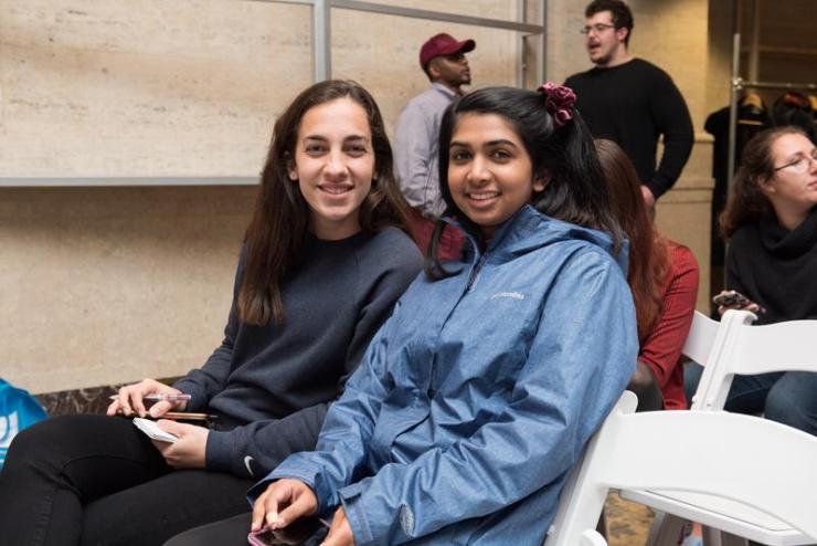 Two people sitting together and smiling at camera