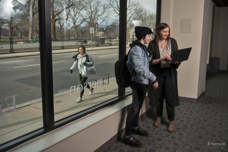 Image of a student walking past an Emerson building