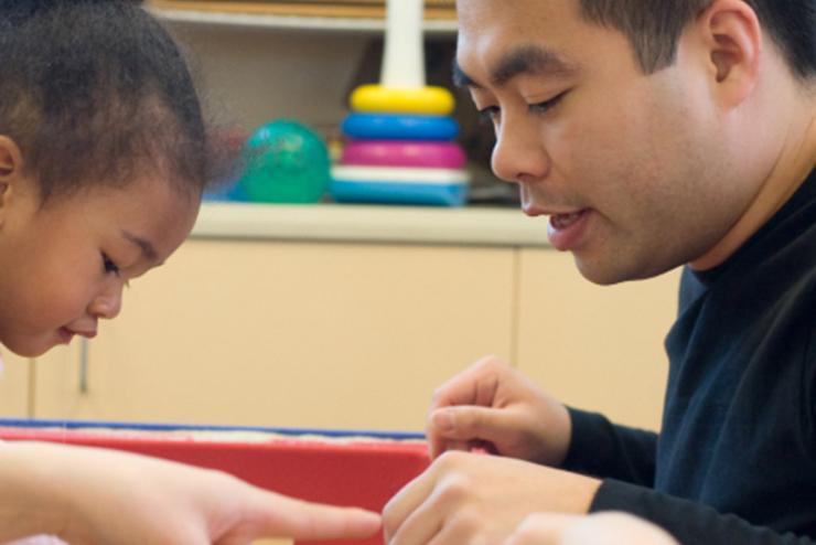 A Communication Sciences & Disorders grad student working with a child