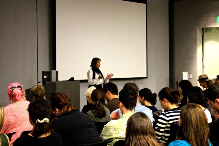 A woman presenting to an audience of students