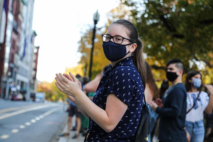 Person wearing a mask and clapping
