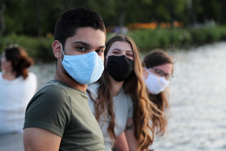 Three people facing the camera wearing masks
