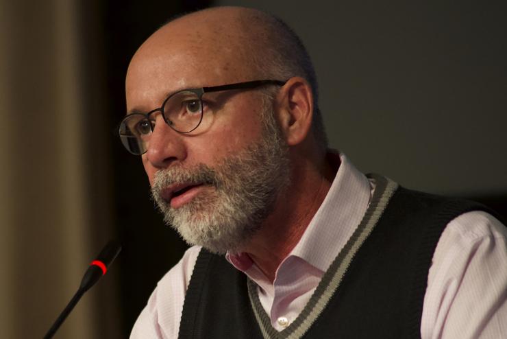 Headshot of Raul Reis on the microphone