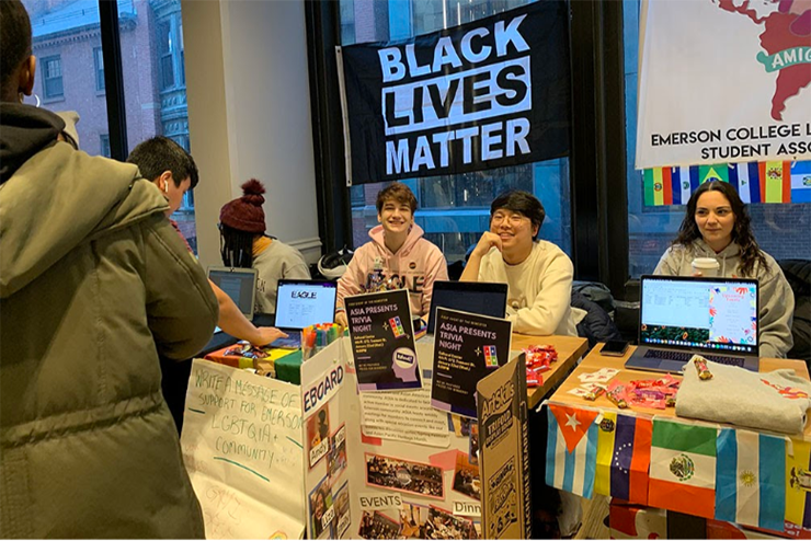 Intercultural Student Affairs booth at organization fair; "Black Lives Matter" banner hung up behind members sitting at booth