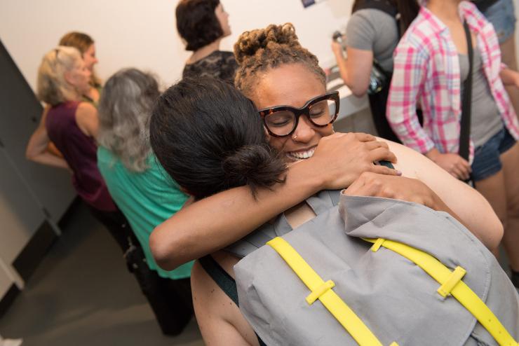 Graduate students embrace at a CMAP event
