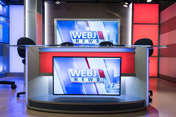 Desk with WEBJ News written on the front of it