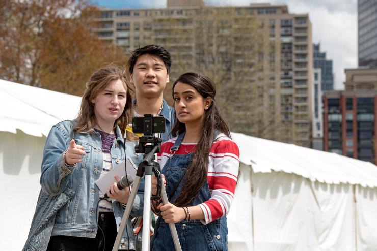 Three students with camera reporting at the Japan festival 