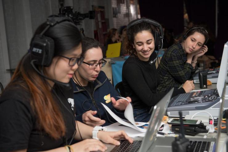 Students wearing headsets at computers, doing media production work