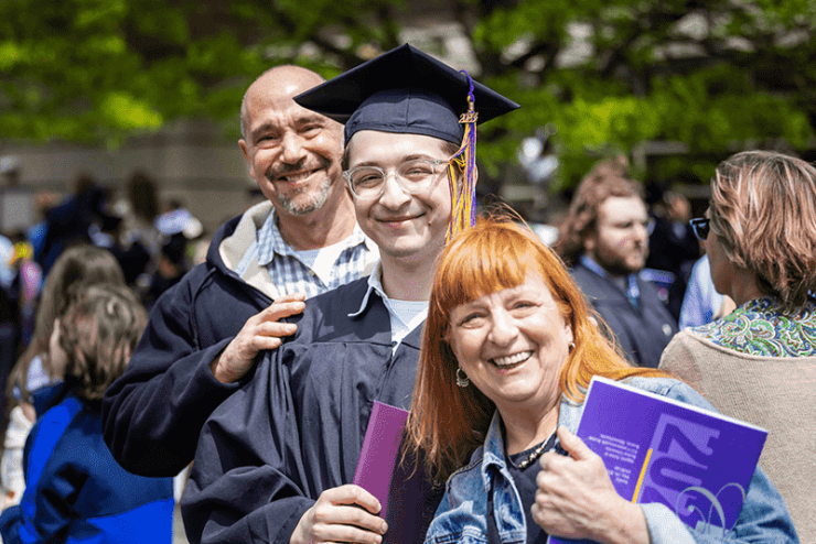 Graduate posing with two adults