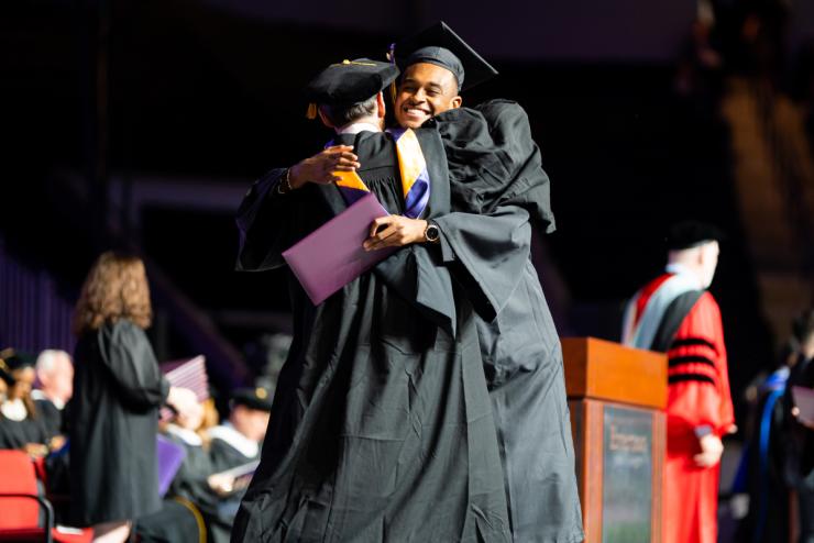 Students embracing at Commencement after receiving their degrees