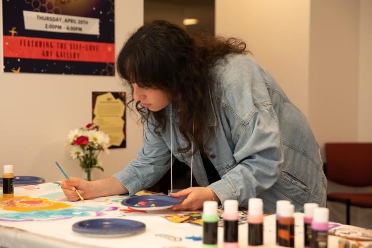 A student working on a craft project with a paintbrush