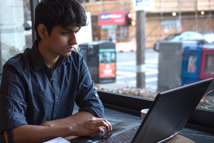 Student sitting at a table using a laptop