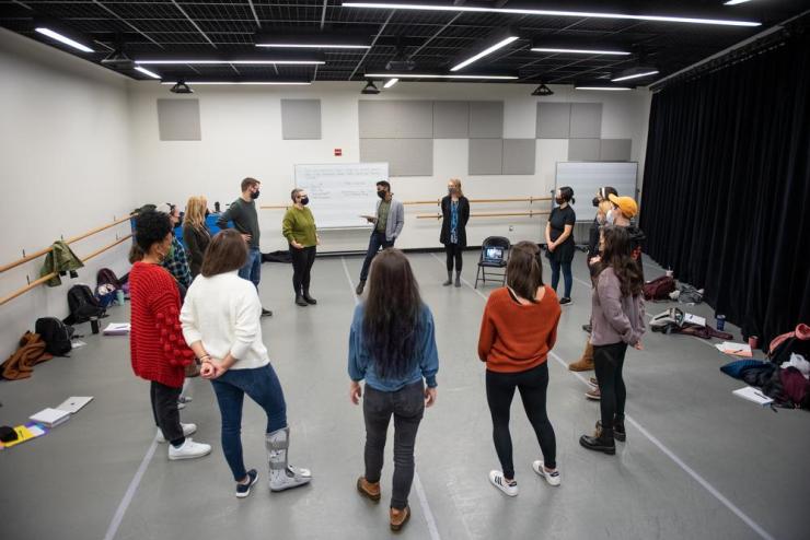 Students standing in a circle within a rehearsal space at Emerson College