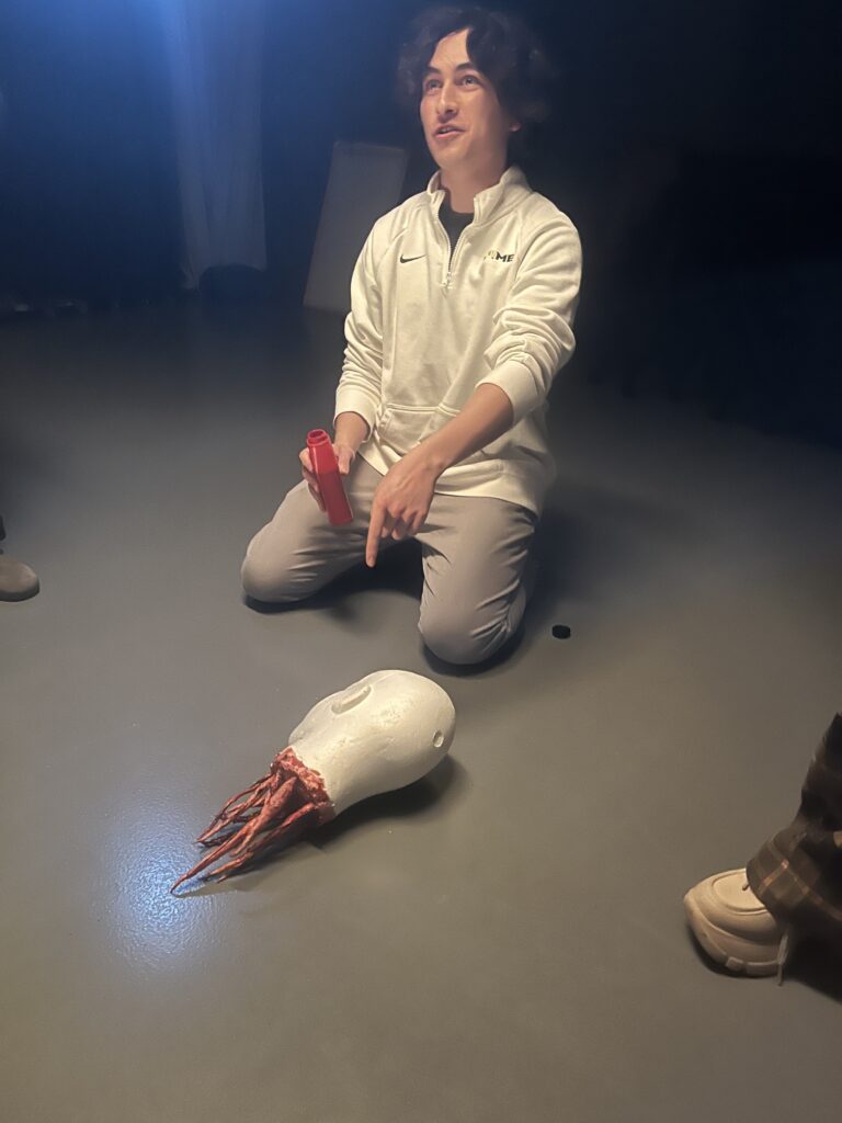 Max Gallen kneels down while filming a scene.