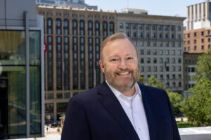 Jay Bernhardt in blue blazer with Little Building