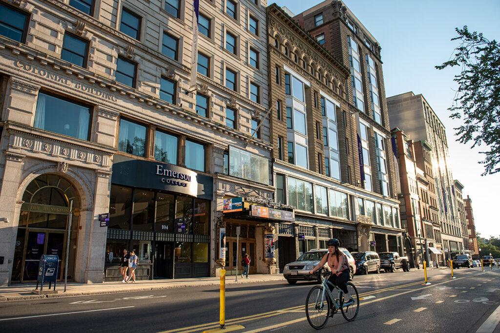 view of campus down Boylston Street with woman riding bike in foreground