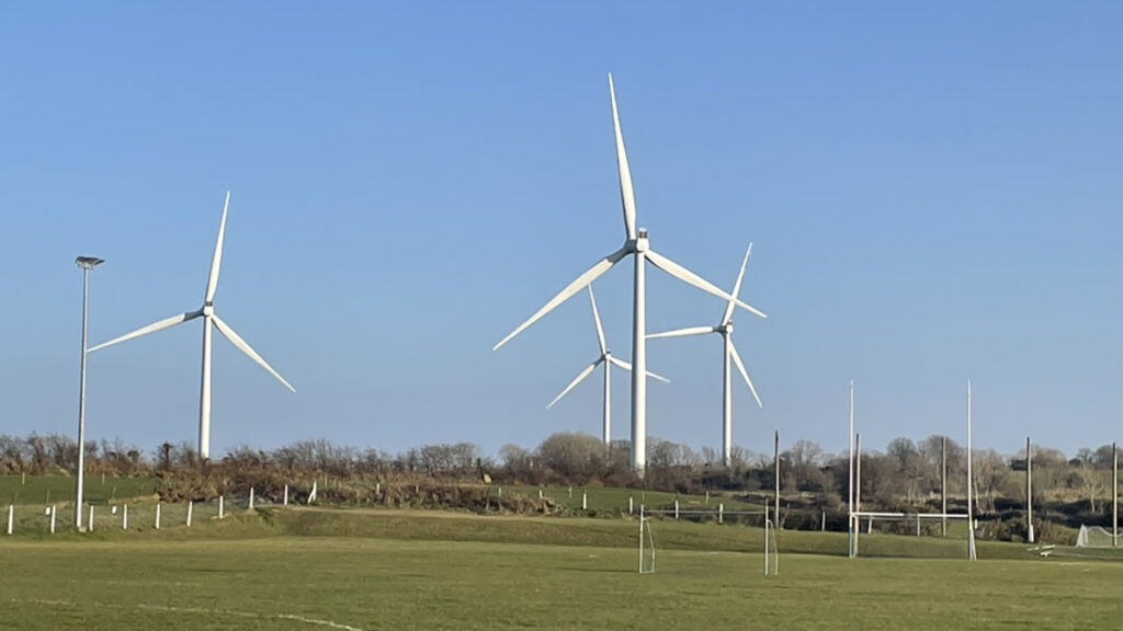 wind turbines tower over a soccer pitch in Ireland