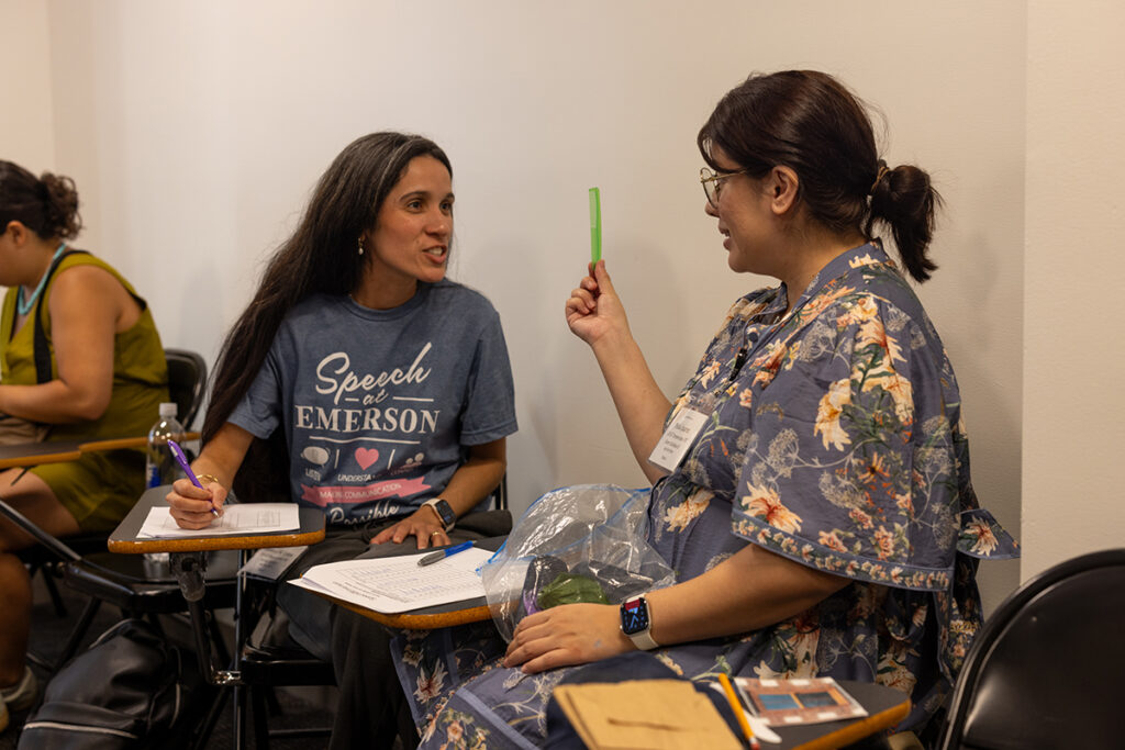 woman holds comb up to other woman