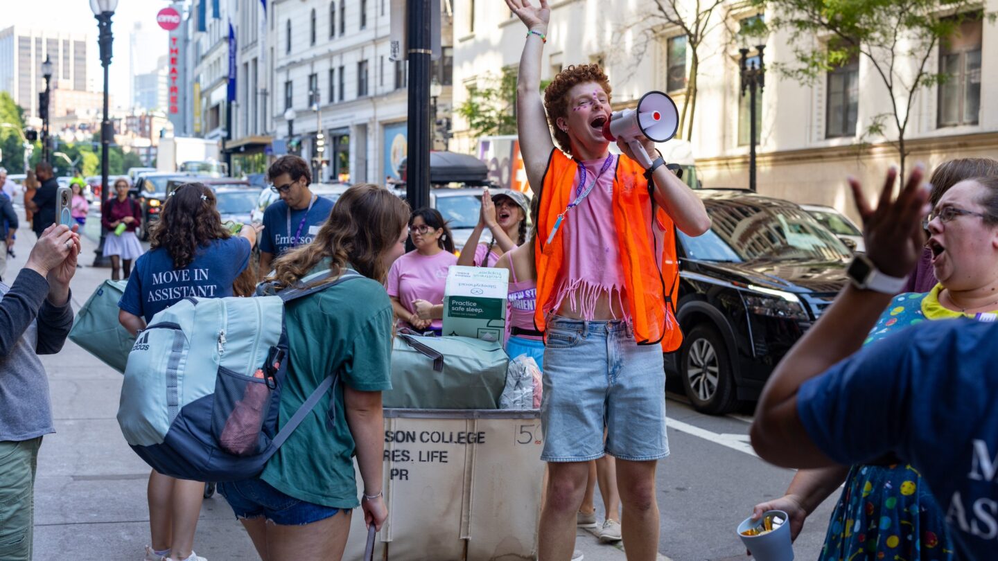 Photo of a student with a megaphone, surrounded by others during move-in