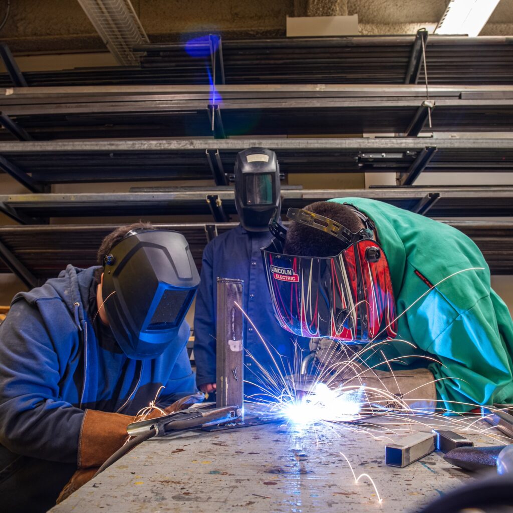 Students weld in the scene shop